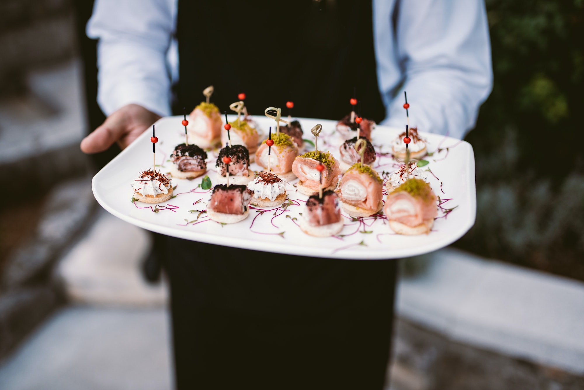 Waiter holding plate with canapés